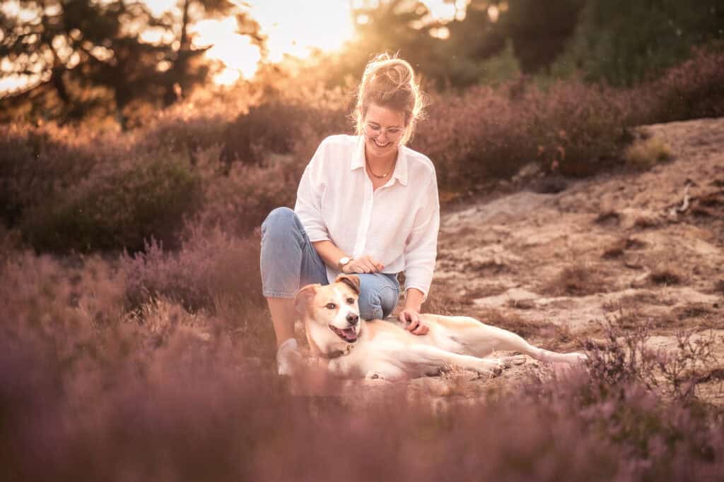 Frau mit Hund im Sonnenuntergang, Natur, Glücksmoment, Outdoor-Fotografie.