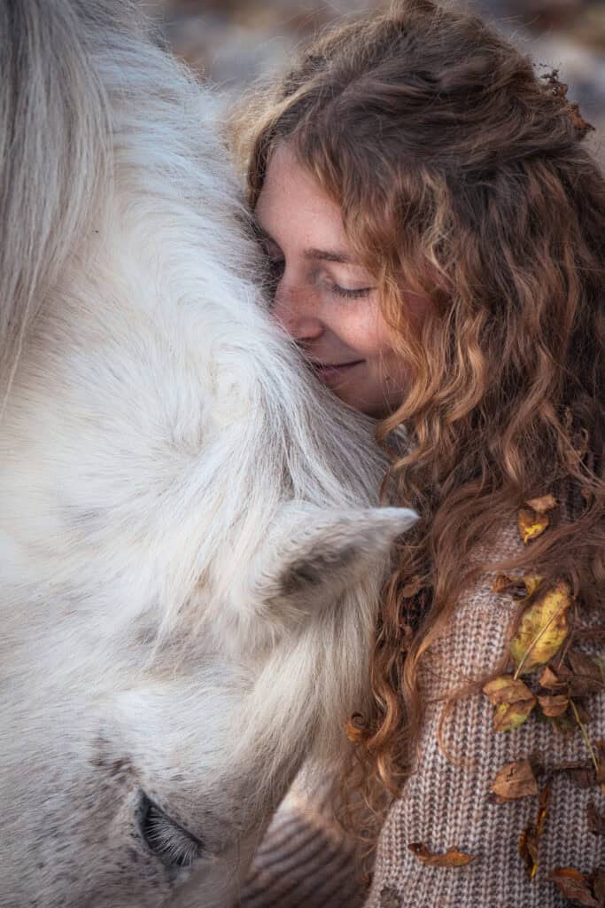Pferdefotografie mit Frau und weißem Pferd, emotionale Verbindung, Natur, Herbststimmung.